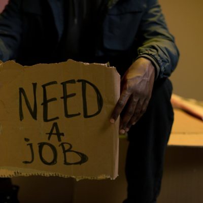 homeless man holding cardboard in hands